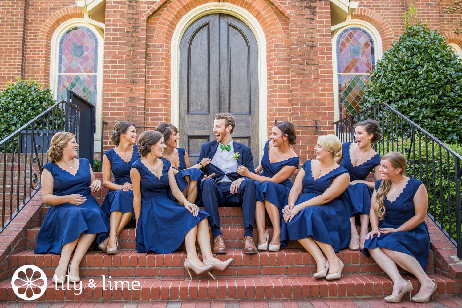 blue bridesmaids posing with candid groom